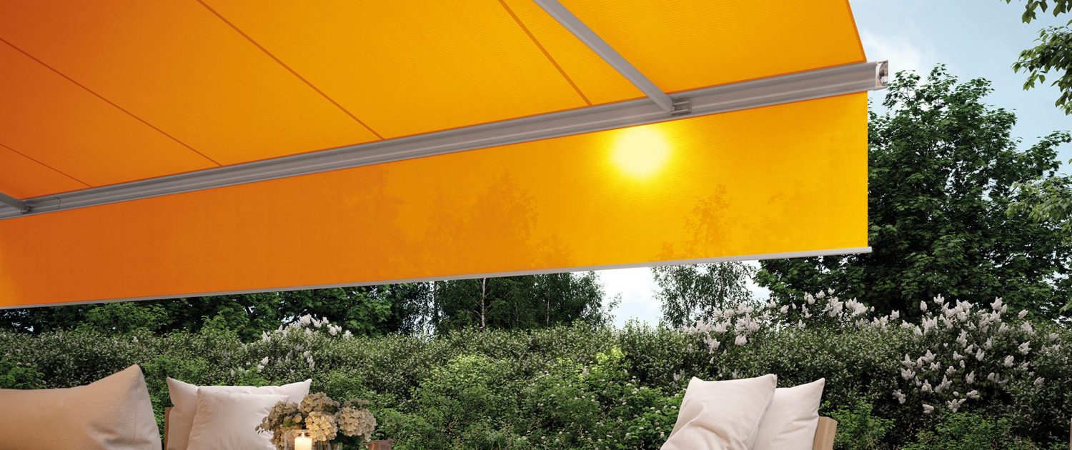 markilux-mx-6000-i-gra-med-orange-dug-og-rullegardin-over-en-terrasse